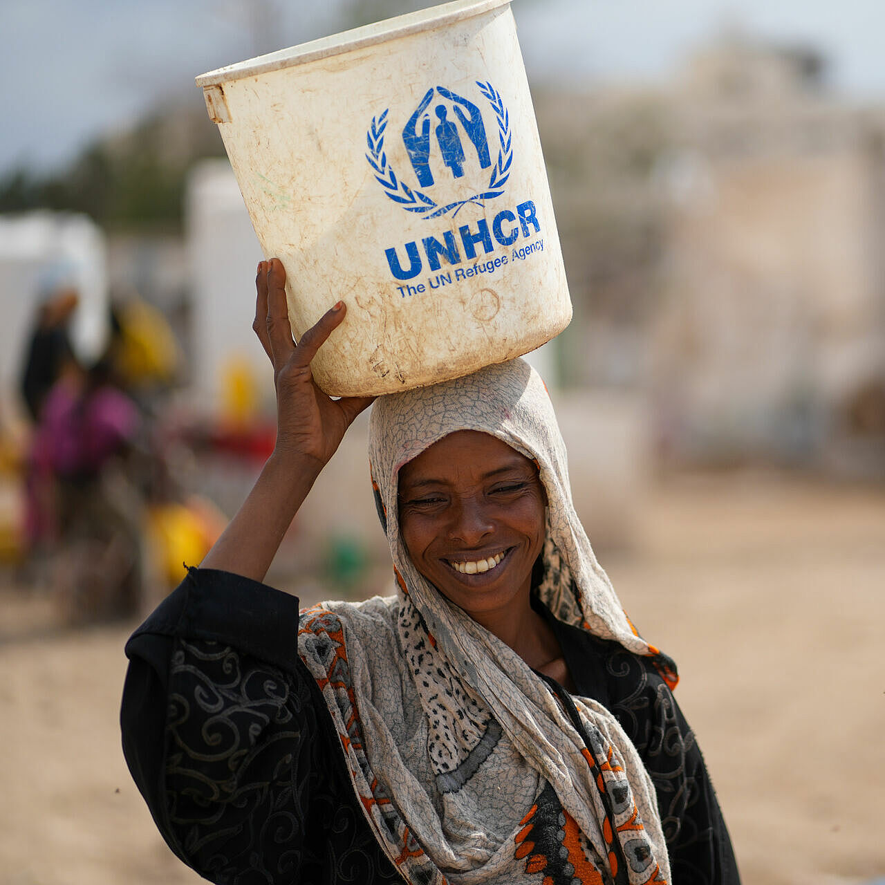 Flüchtlingsfrau mit Wassereimer